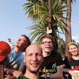2 Fotos der Band Botanica Loca. Die 4 Musiker*innen stehen mit Instrumenten im Freien vor einer großen Palme.